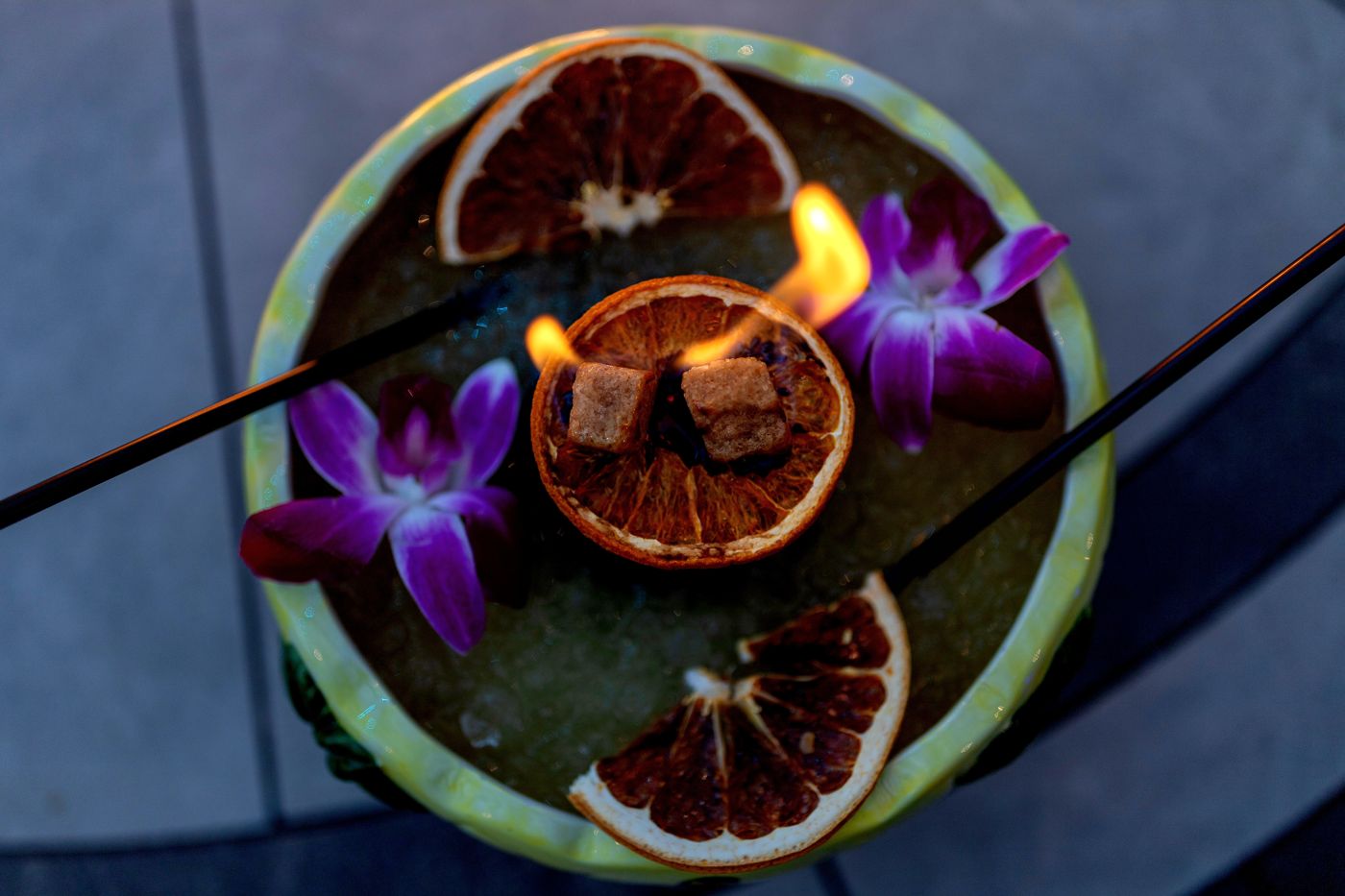 Flaming tiki bowl with dehydrated orange and grapefruit wheels